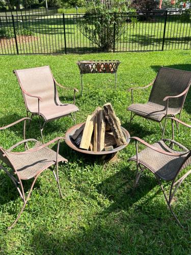three chairs and a fire pit in the grass at 3 Bed, 2 and a half bath Gorgeous Coastal Home 1 block from beach! in Long Beach