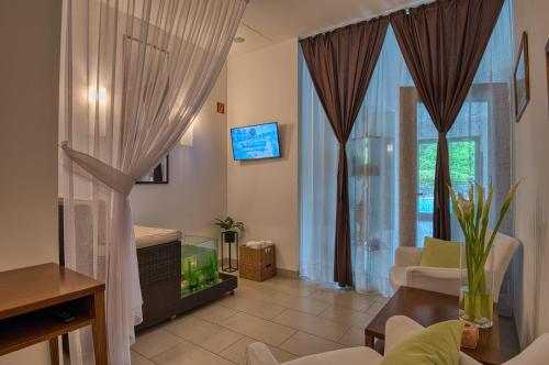 a living room with a fish tank in a window at Tisza Balneum Hotel in Tiszafüred