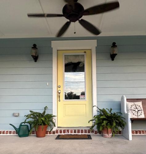 a house with a yellow door and a ceiling fan at 3 Bed, 2 and a half bath Gorgeous Coastal Home 1 block from beach! in Long Beach