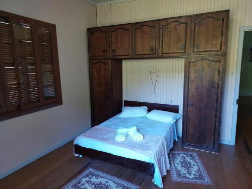 a bedroom with a large bed with wooden cabinets at Colonia Nona Angélica in Farroupilha