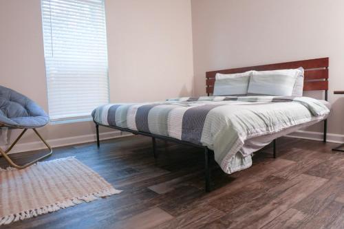 a bedroom with a bed and a chair and a window at Deluxe luxury & convenience in Charlotte