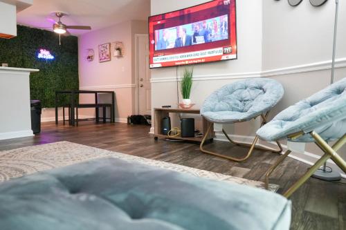 a living room with two chairs and a tv at Deluxe luxury & convenience in Charlotte