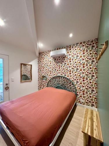 une chambre avec un grand lit et un mur dans l'établissement maison COSY, à Gassin