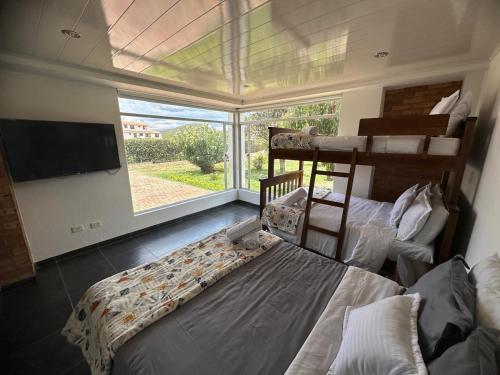 a bedroom with two bunk beds and a large window at Casa El Girasol in Sáchica