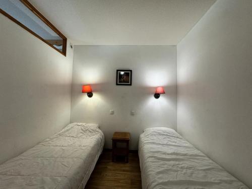 - 2 lits dans une chambre avec 2 lampes sur le mur dans l'établissement Résidence Les Hauts De Preclaux - Logement 6 personnes en rez-de-pistes MAE-5161, aux Orres