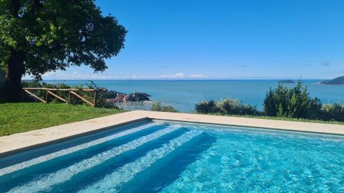 a swimming pool with a view of the water at "Torretta House", inside a Private Park, shared Pool, Tennis, AC, parking next home and parking in Lerici! in Lerici