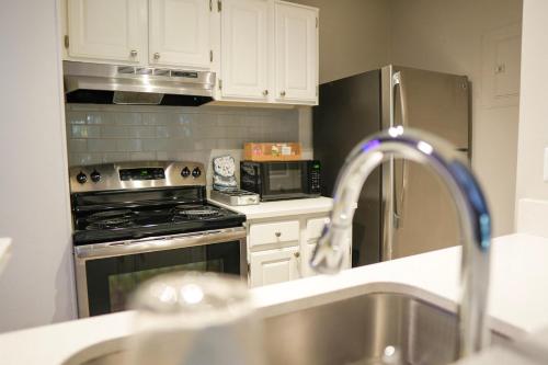 a kitchen with a sink and a stove top oven at Luxury & Convenience in South End Charlotte in Charlotte