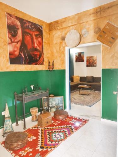 a living room with a large painting on the wall at Dar Margoum in Tozeur