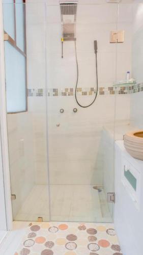 a white bathroom with a shower with a glass door at Casa Mariano in Morelia