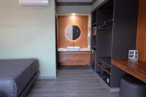 a bedroom with a bed and a bathroom with a sink at Hotel La Quinta Bonita in Ensenada