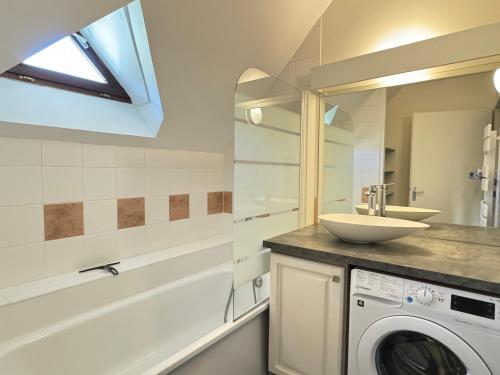 a bathroom with a sink and a washing machine at T2 bis 40M2 5P. Vue. Balcon. Parking. Piscine été. in Cauterets