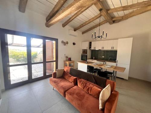 a living room with a brown couch and a kitchen at Charming Sardinian Dream Home in Marazzino