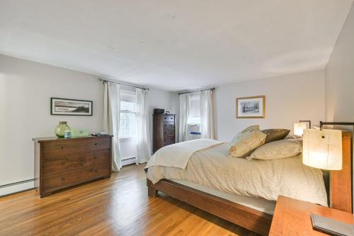 a bedroom with a bed and a dresser and two windows at 10 Mi to Crane Beach Wooded Home Near Boston! in Topsfield