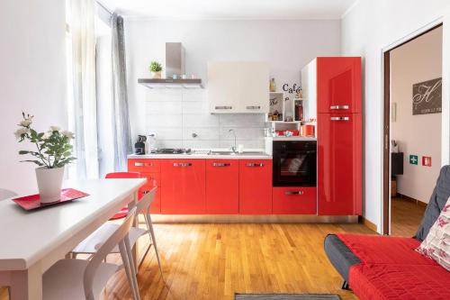 kuchnia z czerwonymi szafkami i czerwoną lodówką w obiekcie Florje House w Rzymie