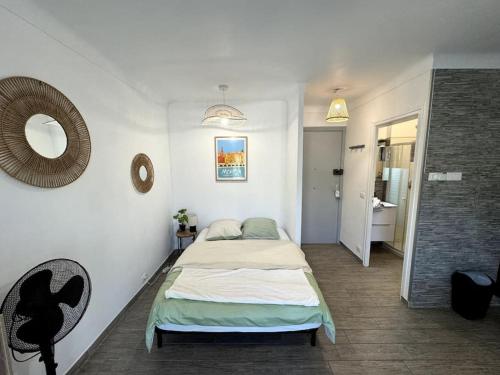 une chambre avec un lit et un miroir au mur dans l'établissement Studio Cosy - Bord de mer, à Menton