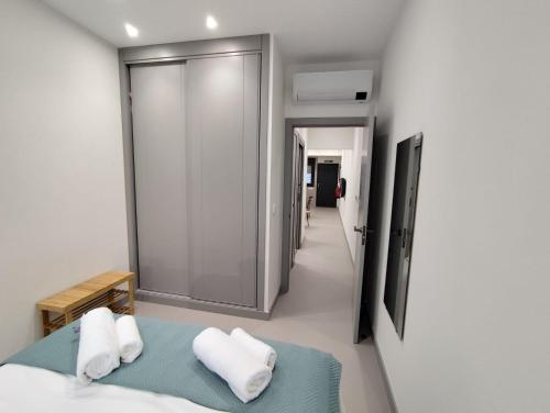 a bedroom with a bed with white sheets and pillows at Apartamentos La Montehermoseña in Cáceres