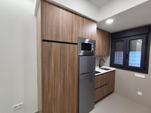 a kitchen with a refrigerator and a sink at Apartamentos La Montehermoseña in Cáceres