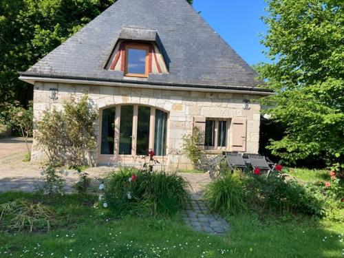 a small stone house with a gambrel roof at La maison des fleurs in Saint-Arnoult