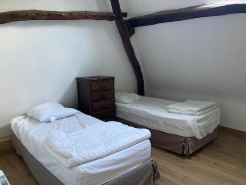 - une chambre avec 2 lits et une commode dans l'établissement La maison des fleurs, à Saint-Arnoult