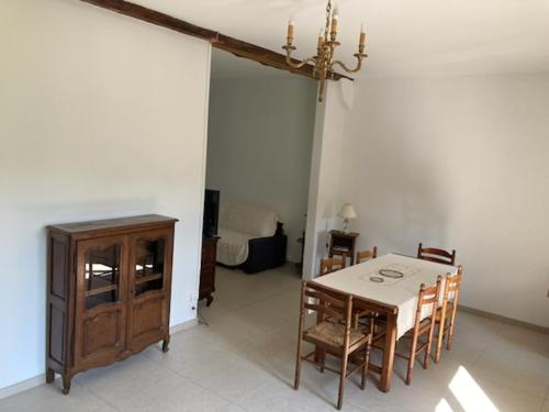 a dining room with a table and some chairs at La maison des fleurs in Saint-Arnoult