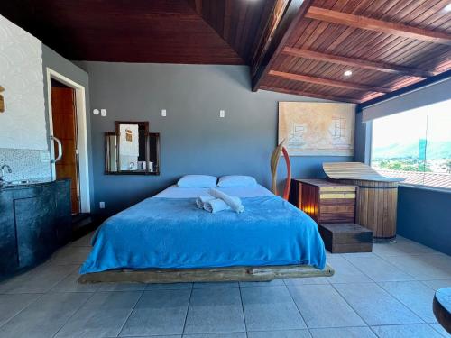 a bedroom with a blue bed and a window at Espaço Verano - Suítes in Niterói