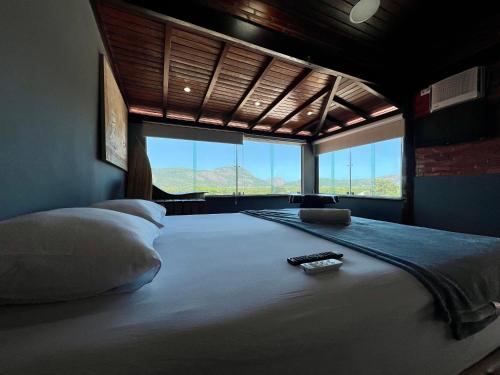 a bedroom with a large bed with a large window at Espaço Verano - Suítes in Niterói