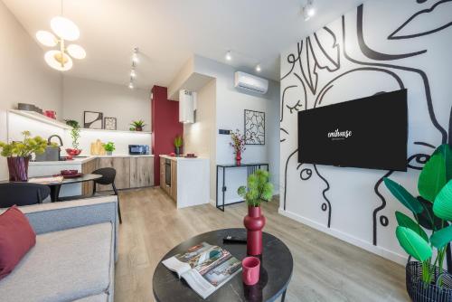 a living room with a couch and a tv on a wall at Emihouse Riverside Apartments in Rzeszów
