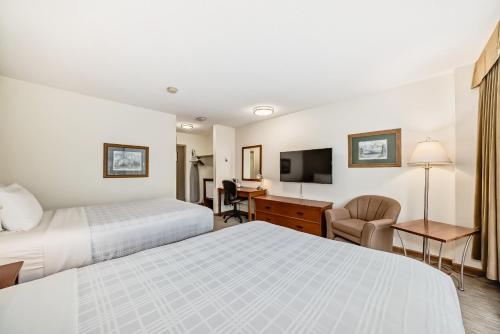 a hotel room with two beds and a desk at Jasper Inn & Suites by INNhotels in Jasper