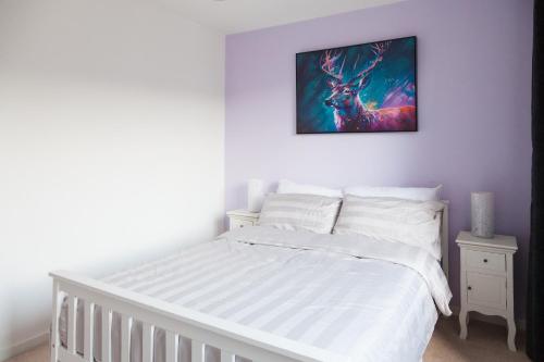 a bedroom with a white bed and a painting on the wall at Balcony View, Fitzroy Court, 2 Bed Apartment, 2 Bathroom - High Wycombe in High Wycombe