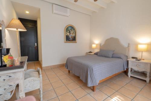 a bedroom with a bed and a table and a mirror at Hotel Boutique Naura Centro in Oaxaca City