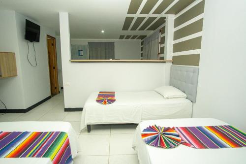 a living room with two beds and a mirror at Hotel Playa Divina in Coveñas