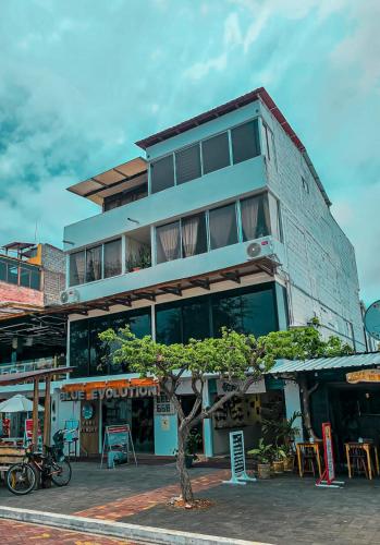 un edificio con un albero di fronte di Plaza Lobos a Puerto Baquerizo Moreno