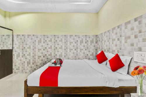 a bedroom with a large bed with red pillows at Hotel O Sridhar in Khammam
