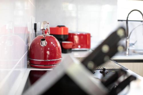 a red toaster sitting on top of a kitchen counter at Air-Conditioned, Self-Catering Apartment with Heated Pool Near OR Tambo International Airport in Benoni