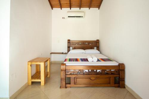 a bedroom with a wooden bed and a table at Hotel Caribe Coveñas in Coveñas