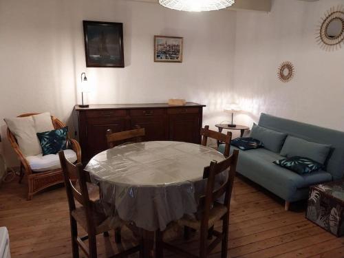 a living room with a table and a couch at La P'tite Maison in Dampierre-sur-Linotte