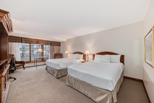 a hotel room with two beds and a desk at Jasper Inn & Suites by INNhotels in Jasper