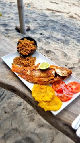 a white plate of food on a wooden table at Sublime Eco Hotel - Palomino Tayrona By GHO Hoteles in Palomino