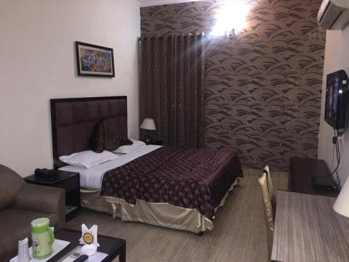 a hotel room with a bed and a couch at Hotel Dreamz Residency in Karnāl