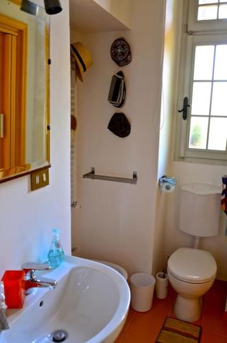 a bathroom with a white sink and a toilet at Casa Biglino, grande casa padronale in Monferrato in Rosignano Monferrato