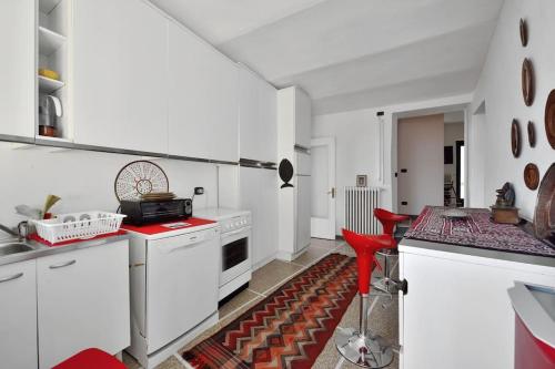 a kitchen with white cabinets and a red stool at Casa Biglino, grande casa padronale in Monferrato in Rosignano Monferrato