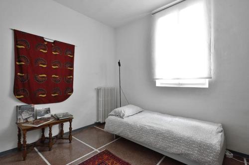 a room with a bed and a table and a window at Casa Biglino, grande casa padronale in Monferrato in Rosignano Monferrato