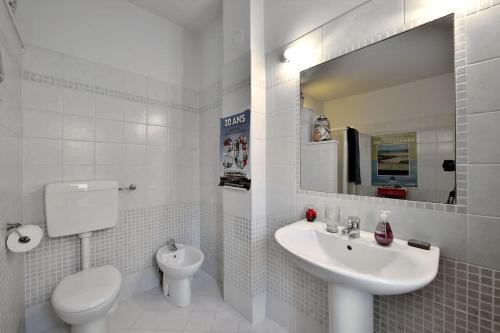 a white bathroom with a toilet and a sink at Casa Biglino, grande casa padronale in Monferrato in Rosignano Monferrato