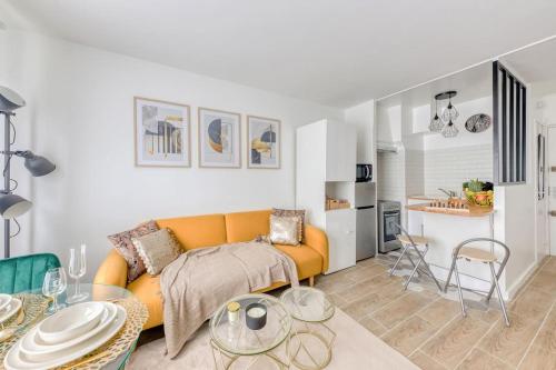 un salon avec un canapé et une table dans l'établissement Charmant T2 proche stade de France et RER B, à Aubervilliers