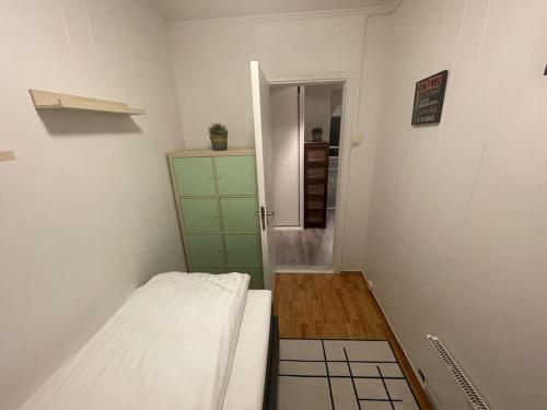 a small room with a bed and a green dresser at Central 2 bedroom apartment in Lillehammer