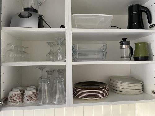 a white cabinet filled with dishes and utensils at Central 2 bedroom apartment in Lillehammer