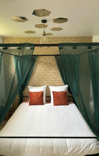 a bed with red pillows in a room at Love room or et rouge in Airan