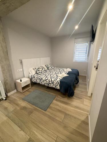 a bedroom with a bed and a rug on a wooden floor at Apartamentos Natura Cantabria in Santillana del Mar