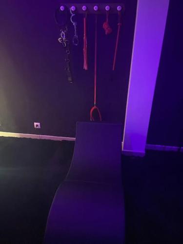 a dark room with a purple room with a chair at Love room or et rouge in Airan