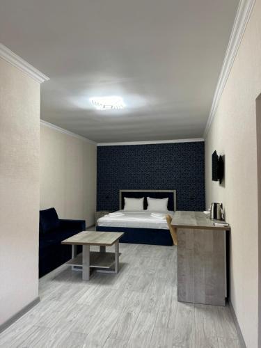 MeghriVARDANANTS HOTEL Meghri的一间带床和桌子的酒店房间
